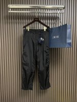 prada 2025Ss新款再生尼龙长裤，这款再生尼龙长裤采用轻盈廓形与经典剪裁。阔腿裤型搭配运动细节，饰有涂珐琅三角形金属徽标。拉链门襟与隐藏式钩扣，正面斜口