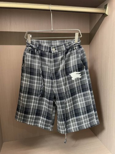 Burberry 2025春夏 尽显经典英伦格调。格纹元素是品牌标志性设计，灰黑格纹沉稳内敛，腰部金属纽扣与调节带设计，增添复古韵味与实用性。品牌专属标识精致绣