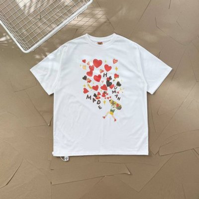 过验级Human Made插画系列浪漫爱心炮人物情侣款短袖T恤 2543 这件T恤上的图案，有一个穿着绿上衣、黄短裤，脚蹬红鞋子的卡通人物，人物手持类似喇叭的物