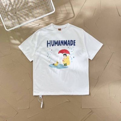 过验级Human Made插画系列雨衣男孩小黄鸭情侣款短袖T恤 2539 这件T恤上，上方有蓝色的“Humanmade”字样 。图案主体是一个穿着黄色雨衣、雨靴