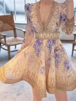 V领宛如优雅的笔触，绘出颈部的优美弧线。长袖上细腻的花纹如同神秘的诗行，裙身印花似缤纷的梦境。收腰设计恰到好处，赋予身形曼妙姿态。大裙摆如云朵般轻盈，每一步都似