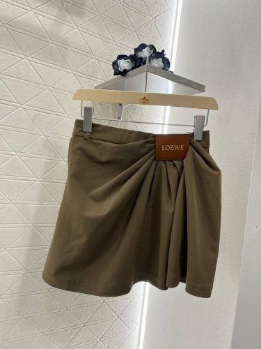 17405# loew*2025新品 皮标褶皱时髦半裙 定制Yb进口西服材质 质感细腻 透气舒适 高街感黑棕两色 单侧捏褶形成斜分走向 以品牌皮标点缀腰间 设计