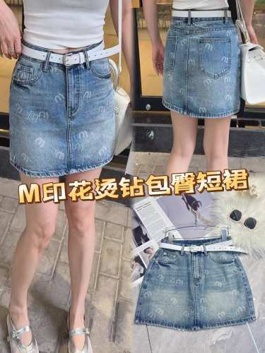m印花烫钻牛仔包臀短裙，是牛仔魅力与潮流元素的完美碰撞。经典牛仔蓝，自带复古滤镜。别致M印花，俏皮又吸睛，搭配闪耀烫钻，瞬间提升精致度。包臀剪裁，勾勒曼妙曲线，