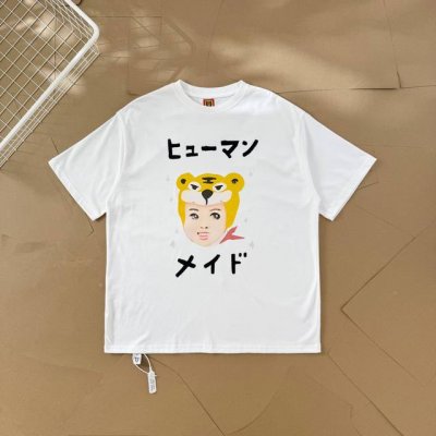 过验级Human Made插画系列老虎头套人物情侣款短袖T恤 2551 这件T恤上的图案是卡通风格。主体是一个戴着黄色老虎头套的人物脸部形象，头套上有老虎的典型