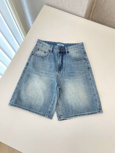 25新款prada 浅蓝色牛仔五分裤 属于经典牛仔单品 采用牛仔布材质 有自然的水洗褪色效果 呈现出复古随性风格 腰部配有纽扣和拉链 设有口袋 兼具实用性与装饰