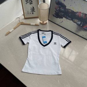 2025新款三叶草女款短袖 这件阿迪达斯V领T恤，以简洁笔触勾勒时尚轮廓。纯净面料，搭配经典黑色领口与袖口饰边，利落V领设计巧妙修饰颈部线条，尽显优雅气质。肩部