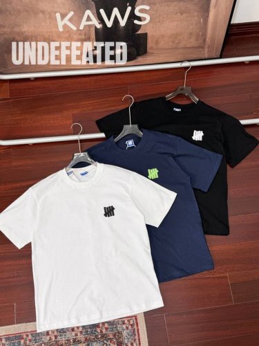顶级版本 Undefeated不败五道杠 Fw25新款 三色超级卡通棒球玩偶情侣短袖T恤 男女同款 Undefeated的Logo是五道杠，它来源于二战时期盟军