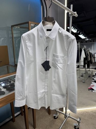 2025 Sspr*Da 男士棉质长袖抗皱衬衫 贸易渠道货品！！ 这款棉质衬衫呈现直筒版型和尖领设计，三角形徽标化身为贴布装点于胸前口袋，演变为阐释品牌身份的精