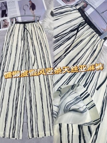 度假氛围感拉满！ 这条竖条天丝亚麻裤，以经典黑白竖条纹为元素，简约又不失格调。天丝与亚麻混纺材质，透气亲肤，带来清凉触感。宽松阔腿版型，修饰腿型，尽显随性慵懒。