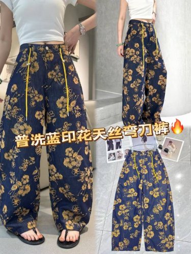 普洗蓝印花天丝弯刀裤，解锁夏日时尚密码！深邃蓝底搭配明媚金黄印花，复古又吸睛。天丝材质，透气亲肤，带来凉爽体验。弯刀版型巧妙修饰腿型，宽松不拖沓。黄色抽绳增添细