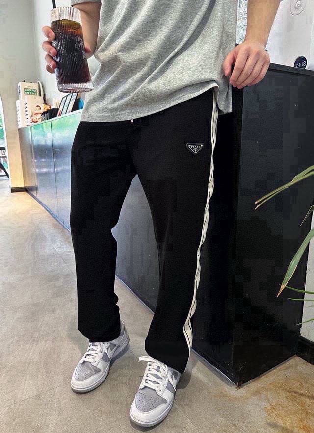 P140 品名：Prada 普拉达24Ss秋冬新款定制三角标针织织带休闲宽松运动卫裤 版型：宽松 颜色；黑色 尺码：M -L-Xl M 裤长99腰围74臀围10