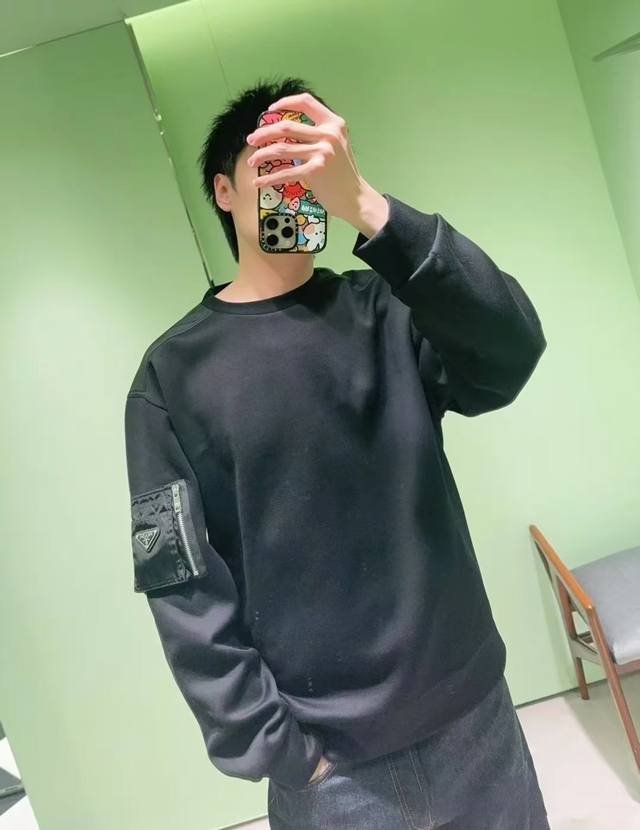 P290。Prada棉质抓绒和再生尼龙运动衫 棉与尼龙的碰撞 这款主体面料为棉质抓绒，将面料表面纤维经过特殊处理，使其产生大量的细小绒毛，这种面料具有保暖、防风