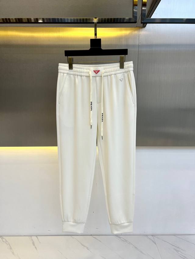 P330 Prad普拉、2025春夏新款男士休闲运动卫裤。选用客供进口针织棉布制成，缜密平顺的针织工艺，使面料整体挺括有型，色泽同样也无比牢固！内里密实的针织肌