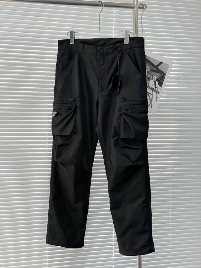 P310。 Prada新款工装裤 ，这款极简夹克面料取材Re-Nylon再生尼龙打造，工装裤两侧拉链多口袋设计 凸显时尚。Re- Nylon再生尼龙通过提纯海洋