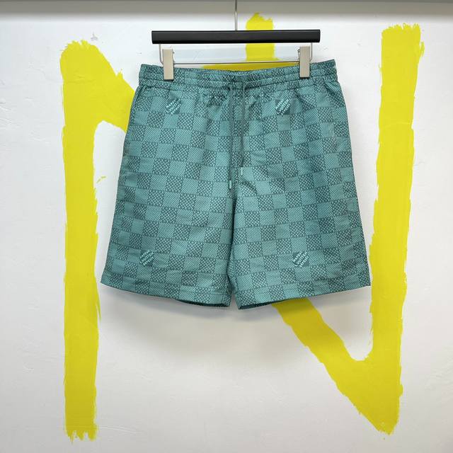 P2501V绿色棋盘格沙滩裤 Size : S-Xl 本款沙滩短裤铺陈全幅 Damier Monogram 图案，将袖珍 Monogram 元素和别致 Marq