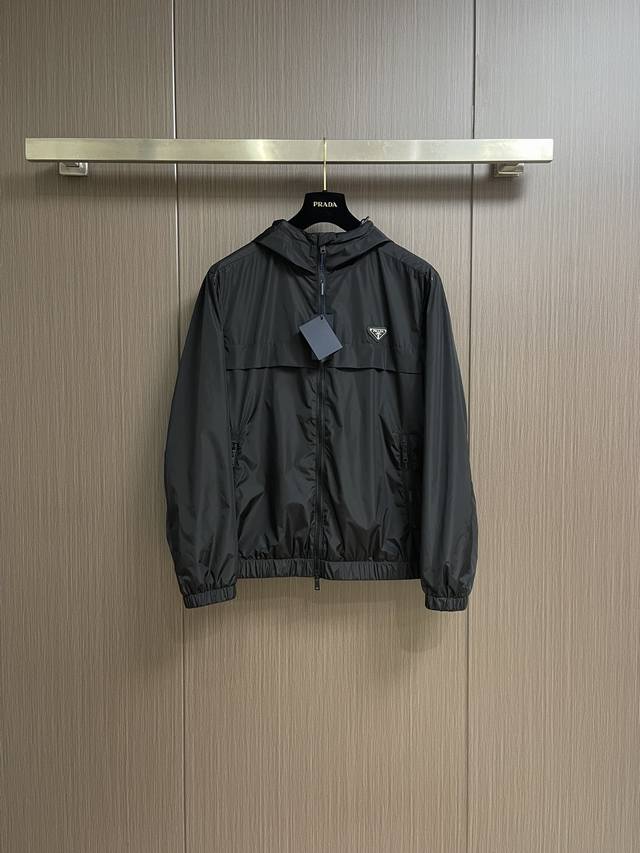 P420！Prada 2025Ss春夏休闲连帽夹克，时尚休闲拉链夹克，此款夹克外套选用了P家专业定制的轻薄科技面料制成，表面整洁光滑且富有光泽，质感透过屏幕都显