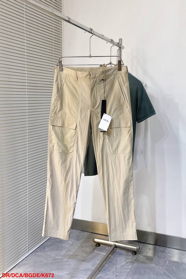 P350 K672 Dior 25新款春夏新款徽标工装裤 这款工装裤采用轻盈弹力100%全棉精制而成。采用中腰设计，多口袋工装口袋，腰后口袋上侧饰有“Dio”徽