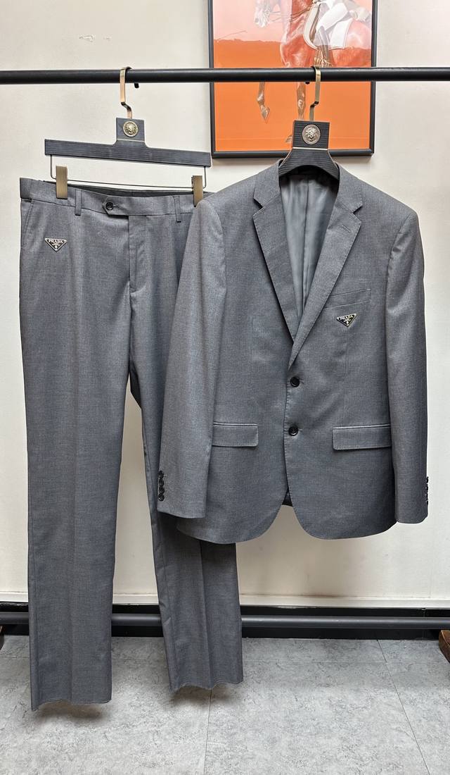 p830/套。 Prada. 2024新款高端商务休闲西服套装，贸易公司渠道臻品，高奢顶尖品鉴货。整体的造型设计，沿袭了现代极简主义基调，时尚两粒扣设计，进口面
