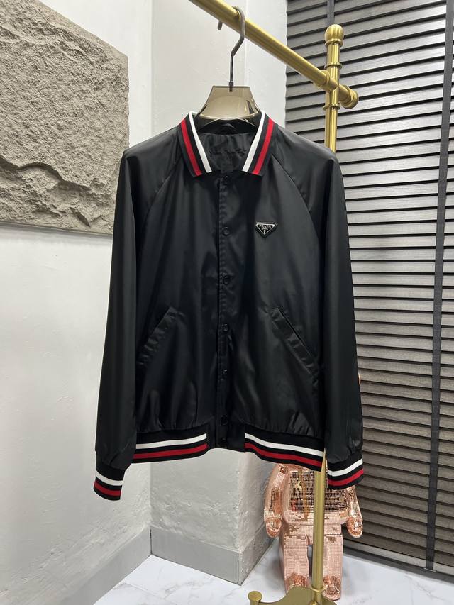 p370 Prad 25新款再生尼龙夹克，这款夹克由Prad系列代表材质的升级版本Re-Nylon制成，呈现Oversize造型，点缀罗纹袖口与针织领，胸前经典