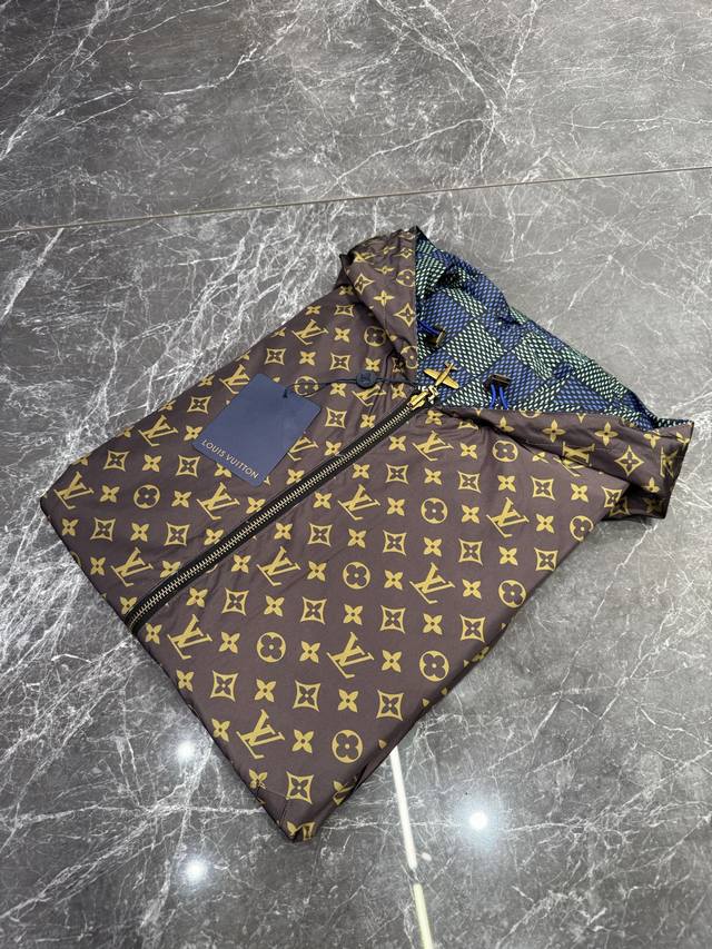 Lv 25Ss新款双面防风夹克出自 2025 春夏秀场，以摩登视角诠释 Damier 格纹，翻转即现全幅 Monogram 图案。飞机造型金属拉链头工致镂刻品牌