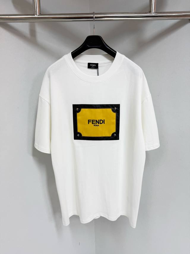 Fendi 拼皮字母贴布圆领短袖 纯棉面料、正面饰有金色蛇眼图案、搭配标识字母印花、珍珠母纽扣、采用50S双股260G；印花之间细节处理非常到位，无毛边及过界痕
