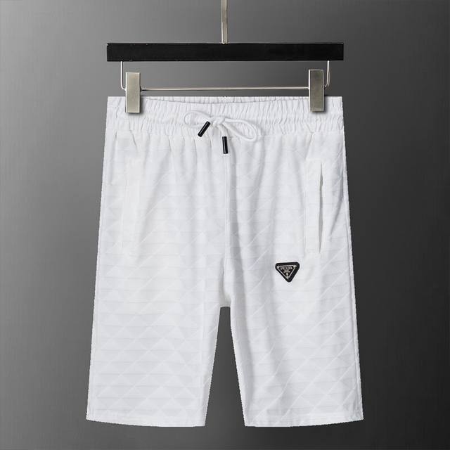Prada 普拉达 2025年春夏新款男装休闲短裤，三角形提花面料，搭配皮牌，款式时尚 帅气，面料舒适，做工严谨 ，走线工整。上身效果好 码数 M-3Xl 白色