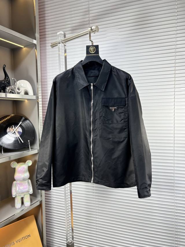 Prad*普拉达 Ss25早春新款夹克外套。采用客供高密度精材质面料，软糯亲肤，抗皱立挺有型，品牌字母Logo，满满的时尚感；适合多种穿搭风格；一款不挑年纪的外