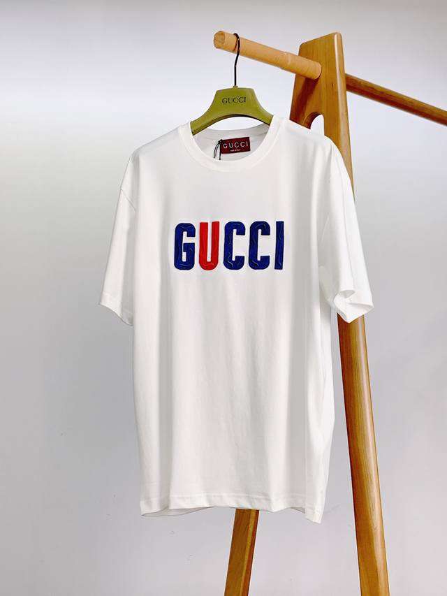 Gucci 古驰 2025Ss春夏新品 字母刺绣T恤。甄选优质高支纯棉面料打造，采用高密度针法构筑浮雕质感，胸前字母以钻石红 深海蓝丝线织就立体棱角，表面叠加意