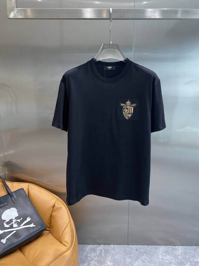 芬家 Fendi黑T，徽章元素的时尚魅力 左胸口处的金色徽章图案，精致又独特。徽章上的细节满满，搭配周围的标志性图案，彰显着品牌的奢华与个性。小小的设计，却成为