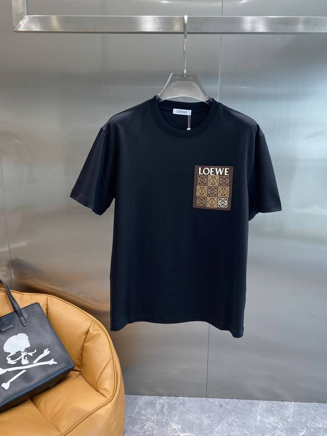 罗家 Loewe黑T，精致标识的低调奢华！纯黑色的衣身，简约大气，经典又百搭。 左胸口处的方形标识太吸睛啦！“Loewe”字样搭配精致的花纹图案，以棕色呈现，低