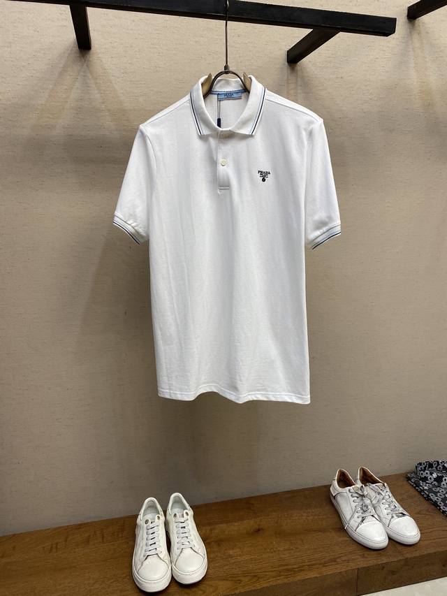 Prada.普拉达 春夏单品正面胸前饰有品牌经典字母刺绣标识Polo衫，Zg同款，胸前标志性刺绣设计彰显品牌辨识度，弹力棉Polo衫简约而不失精致，释放休闲魅力