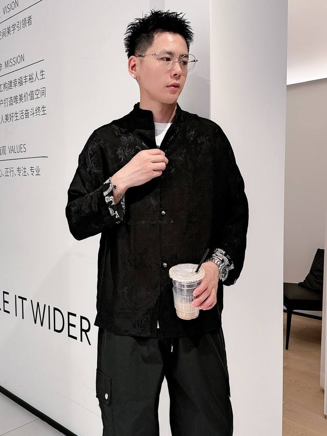 25年春秋新款 国潮男士休闲外套 这款新中式外套 将传统与现代完美结合。它采用了传统的小立领设计，留住经典的同时又不失时尚感。纽扣选用的是点睛的水墨画玉石扣，细
