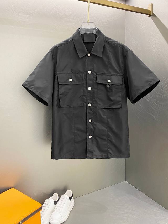 暗黑尼龙 Prada三角标立领短袖衬衫 ！2025Fw新款休闲短袖衬衫，面料采用防风尼龙定制面料，高缜密凤眼开扣口，细节完美到极致 ！ 领标 三角标均为定制辅料