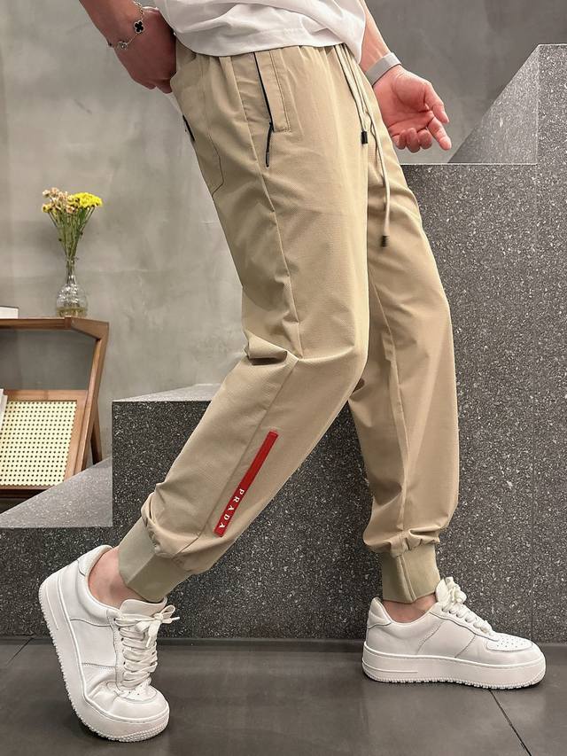 Prada# 2025 天丝锦纶四面弹春夏休闲裤子 美学的焕新诠释,演绎浓郁的格调型时尚风范,细节感和设计感强悍.经典品牌标识做为色彩搭配,演绎经典的品牌时尚,