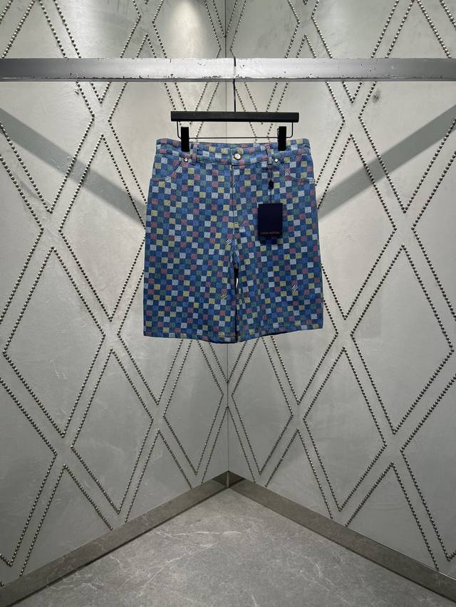 驴家 25Ss春夏新款青年布短裤以缤纷原色描绘新季 Lv Vers Damier 图案，其间穿插 Marque L.Vuitton DéPoséE 标识。珠光铆