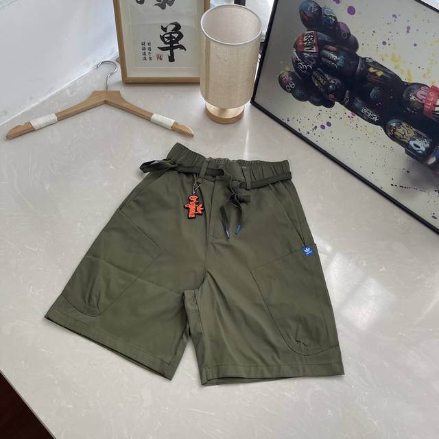 三叶草2025新款短裤 时尚弄潮儿们看过来！这两款短裤，将成为你夏日衣橱的耀眼担当。 黑色短裤，经典百搭永不过时。抽绳设计增添随性感，可自由调节松紧。亮眼的橙色