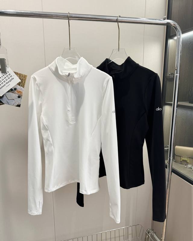 品名：Alo 反光Logo半拉链修身瑜伽防晒衫 尺码：S.M.L 颜色：白色 黑色 品质炒鸡好的一款运动型瑜伽服 舒适透气，高弹力运动型面料 亲肤舒适柔软 姐妹
