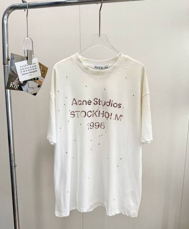 品名：Acn* Studios新款 1996做旧扎染烫钻短袖 尺码：S.M.L 颜色：白色 不需要精致的妆容和完美的身材，也能穿出和她们一样的松弛感。这就是Ac