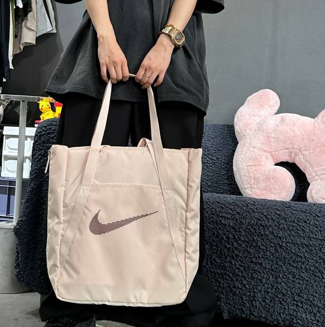 立体标 高品质 耐克Nike托特包单肩包手拎包男女同款。 这款包包色系非常耐看，容量大内置多个夹层 可放置13寸笔记本。 旁边两侧收口拉链 拉开可增加容纳空间。