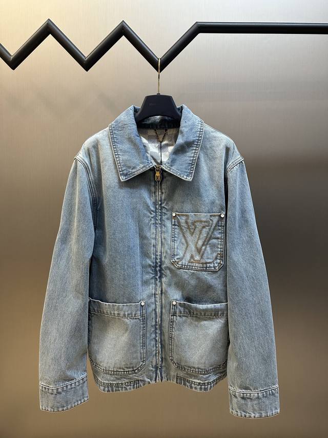Lv 拉链工装牛仔夹克 本款工装拉链牛仔夹克取材细腻棉布，以水洗工艺营造轻微做旧效果，成就温暖时节的轻盈之选。Lv刺绣胸袋和后部正绒面革Lv 贴饰彰显考究细节，