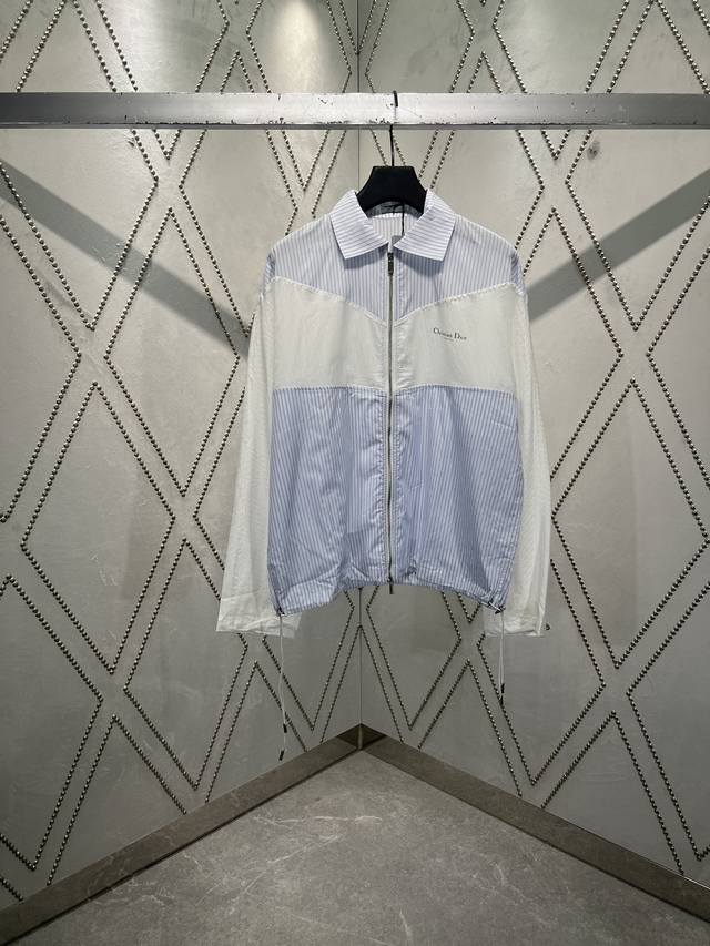 迪奥 夏季男装系列新品，重新诠释经典廓形，彰显运动风格。采用白色条纹棉府绸和 Oblique 印花棉质提花面料精心制作，搭配抽绳底边，双材质剪裁，正面饰以 Ch