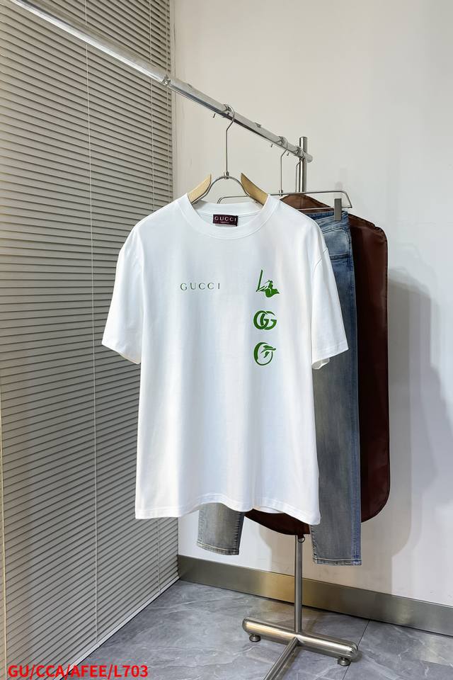 L703 Gugucci 25Ss新款印花短T 干净的白色上，亮眼的荧光绿元素格外吸睛。一侧印着醒目的“Gucc”字样，还有独特的图案和经典的双G标志，瞬间提升