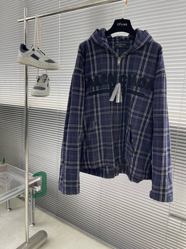 Balenciag 2025早春格子拉链连帽外套 采用高克重棉质混纺 含微量弹性纤维 ，确保硬挺度与舒适度的平衡。格纹由深紫、炭黑及灰调经纬纱线交织，通过微调纱