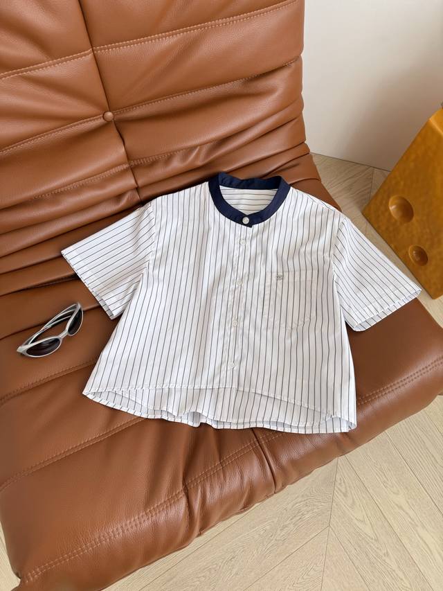 25春夏 撞色小立领拼接条纹衬衫 很有设计小心机的一件衬衫 前片是双层面料假两件拼接 前短后长设计 上身在视觉感上分割出高挑身材比例 口袋上钉水钻双C小金属 和