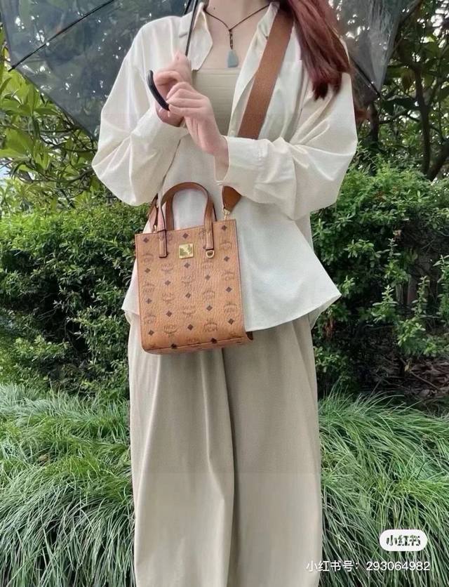 mcm 手提包，送小狗挂件 Mcm 新品手提袋，真是方便又实用哦！ 包型立体，特别的有型，大小刚好，款式简约大气，采用宽肩带的设计，背起来特别舒适～ 且正式中又