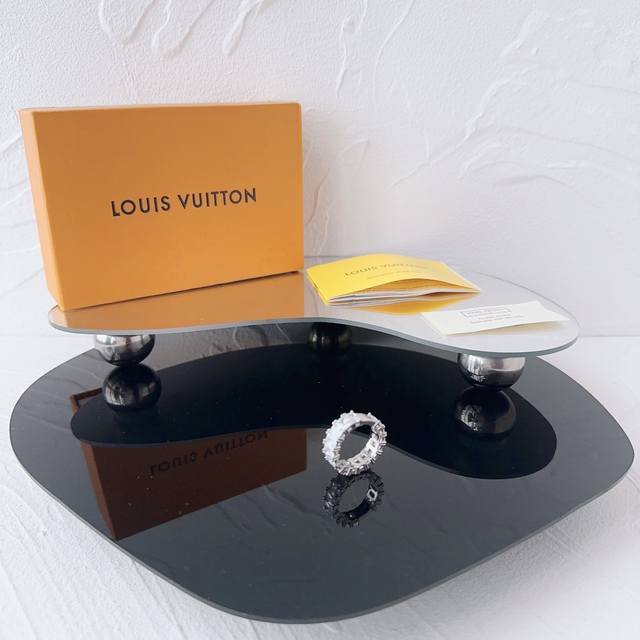 lv 雕刻Logo字母 锆石戒指 情侣款 奢华与艺术的完美融合，情侣款银色这款戒指独具匠心的设计，将品牌的经典元素与现代时尚完美结合。戒指上精心雕刻的图案，搭配