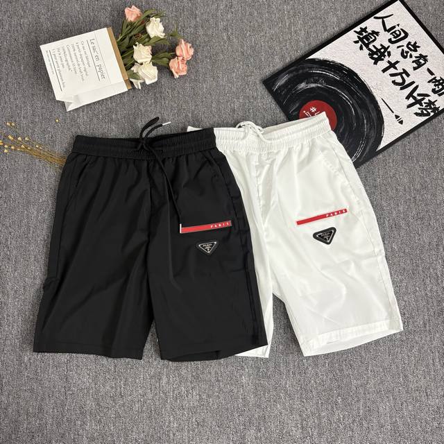 prada 普拉达 三角标工装口袋机能短裤 面料：定制三防全功能尼龙面料 防风防水防晒 触感如同末来科技 轻盈又坚韧 舒适贴肤 涂珐琅三角形金属徽标彰显品牌 以