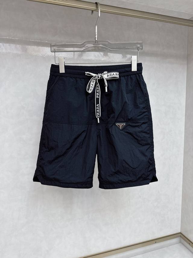 普拉达 2025夏季新款男士休闲短裤，高级定制面料透气面料 透气弹力舒适度极高，细节无可挑剔，顶级辅料配备，原版Logo设计理念，手感细腻柔软！上身版型超赞！尺