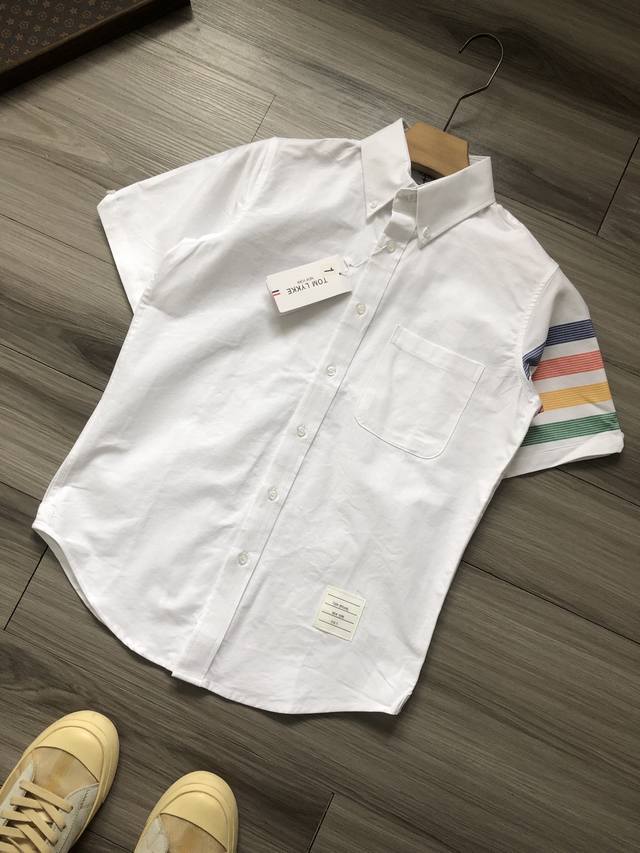 Tb丨 Thom Browne 汤姆布朗 彩红臂环四条杠纽扣男女情侣款牛津纺短袖衬衫. 颜色 白色. 材质 纯棉牛津纺. 工艺 水洗. 尺码 1 2 3 4 5