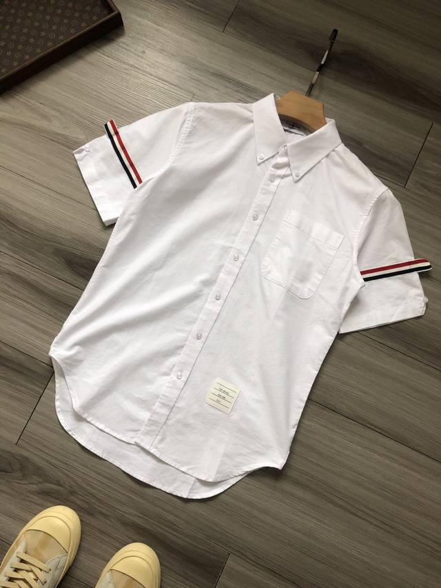 Tb丨 Thom Browne 汤姆布朗 臂环织带条纹纽扣男女情侣款牛津纺短袖衬衫. 颜色 白色. 材质 纯棉牛津纺. 工艺 水洗. 尺码 1 2 3 4 5.